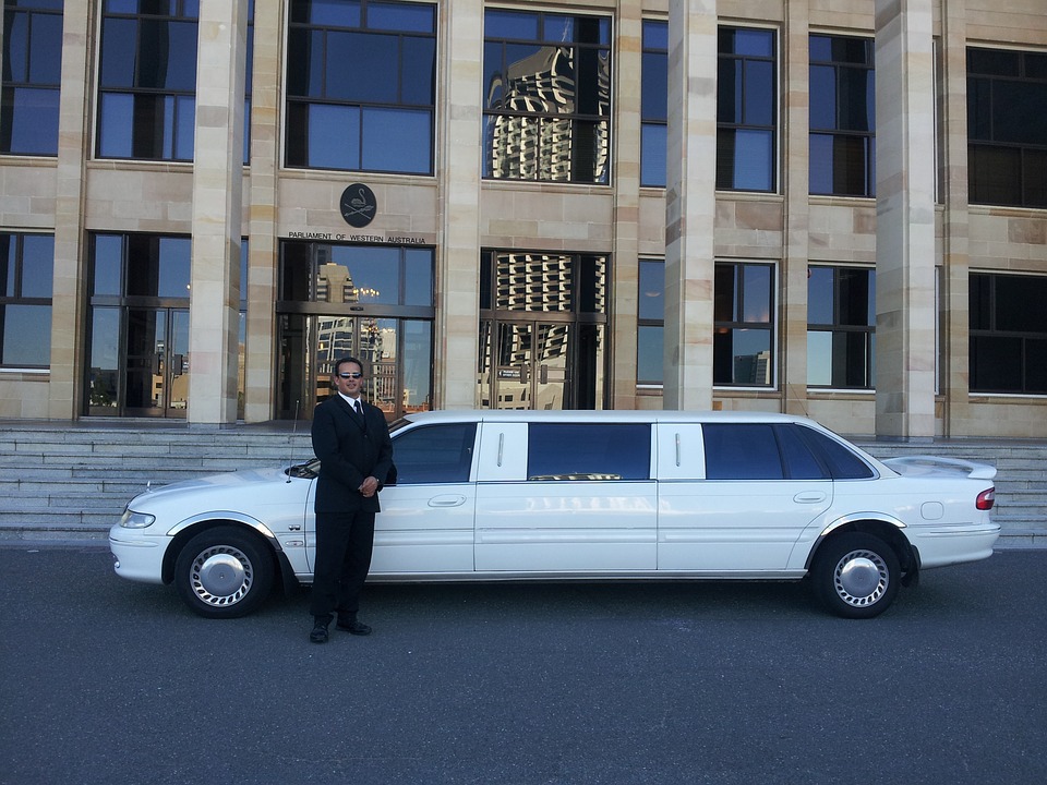 A man standing next to white limo
